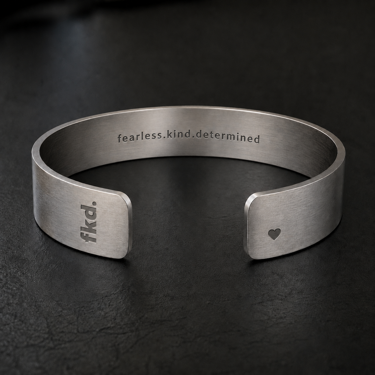 fkd Core 1.0 male concept — premium minimalist metal cuff with engraved fkd logo and heart NFC area